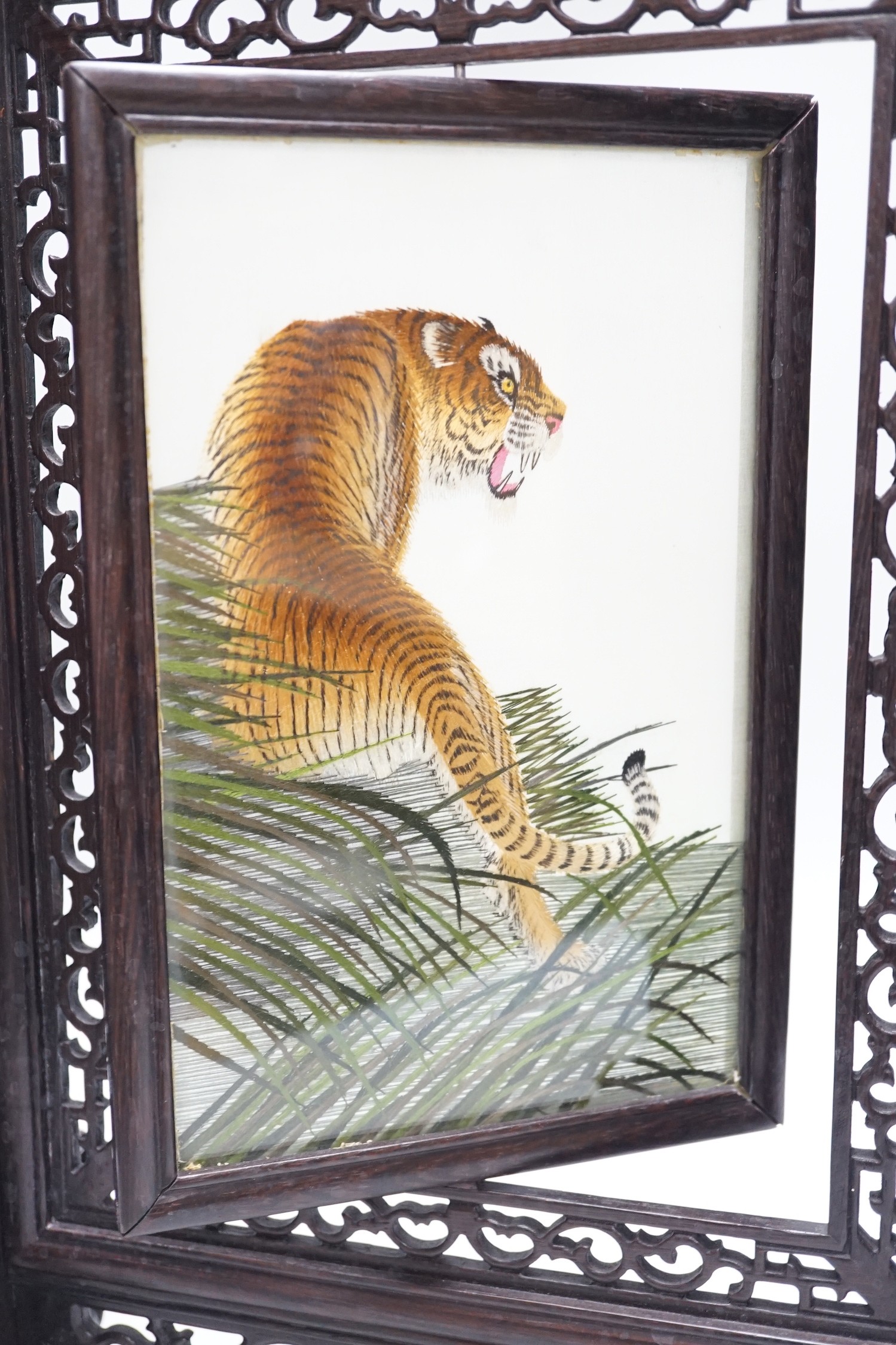 A Chinese reversible silk embroidered panel of a tiger in a revolving screen and hardwood carved frame, 45cms high